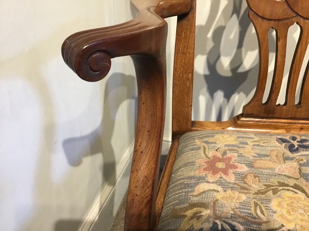 A George III mahogany elbow chair featuring a pierced scroll splat back, shaped armrests, and a multi-coloured floral tapestry drop-in seat. View VII