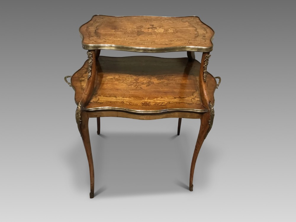 A two-tiered French etagere table featuring floral marquetry inlay, decorative brass mounts, and slender cabriole legs.