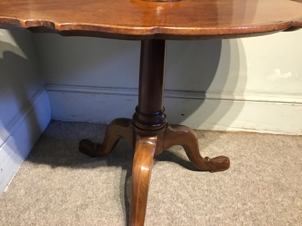 An antique mahogany two-tiered dumb waiter featuring scalloped tray edges, a turned central column, and a tripod base. View VI