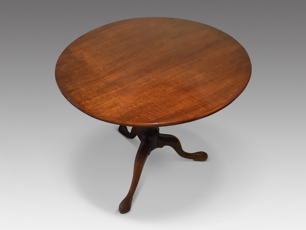A dark mahogany circular tripod table with a turned central column featuring spiral carving and three cabriole legs with pad feet. View II