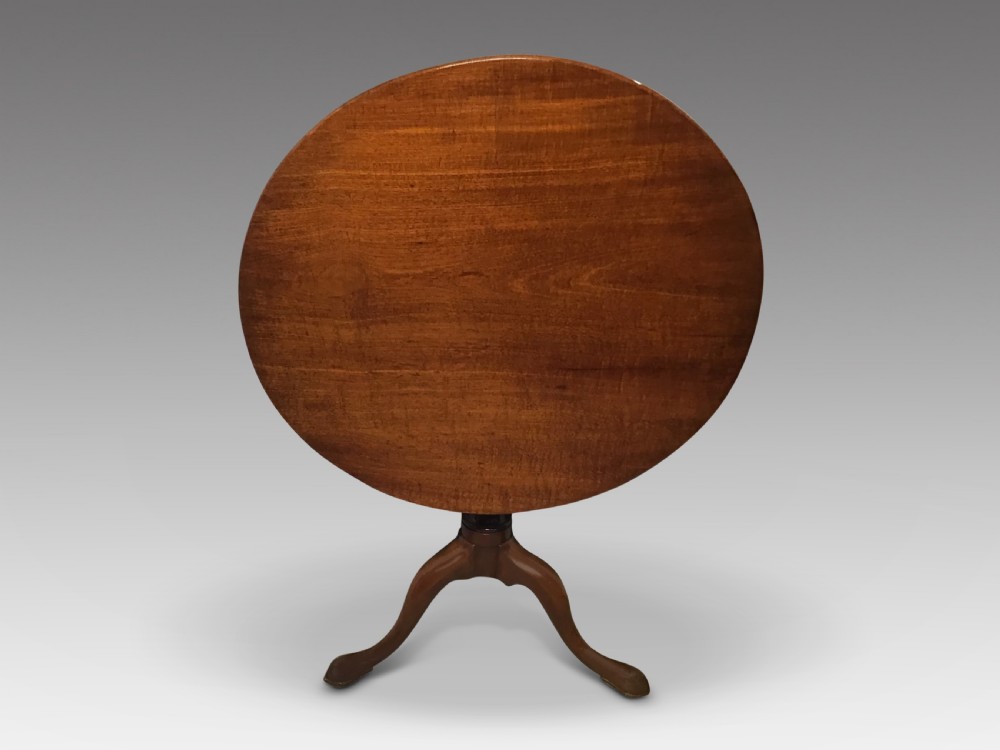 A dark mahogany circular tripod table with a turned central column featuring spiral carving and three cabriole legs with pad feet. View III