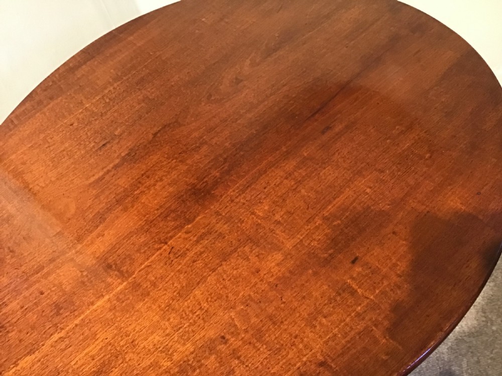 A dark mahogany circular tripod table with a turned central column featuring spiral carving and three cabriole legs with pad feet. View VIII