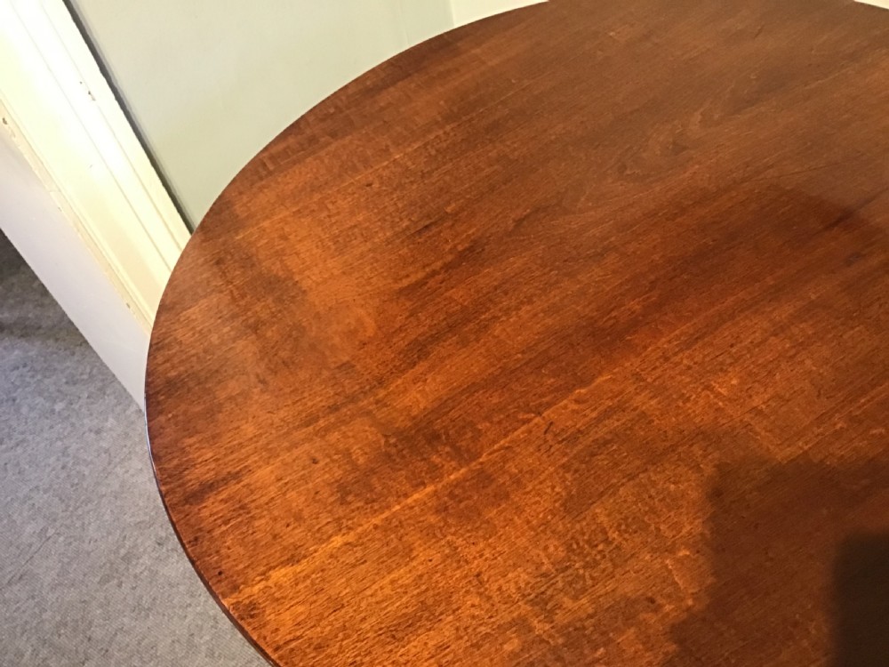 A dark mahogany circular tripod table with a turned central column featuring spiral carving and three cabriole legs with pad feet. View IX