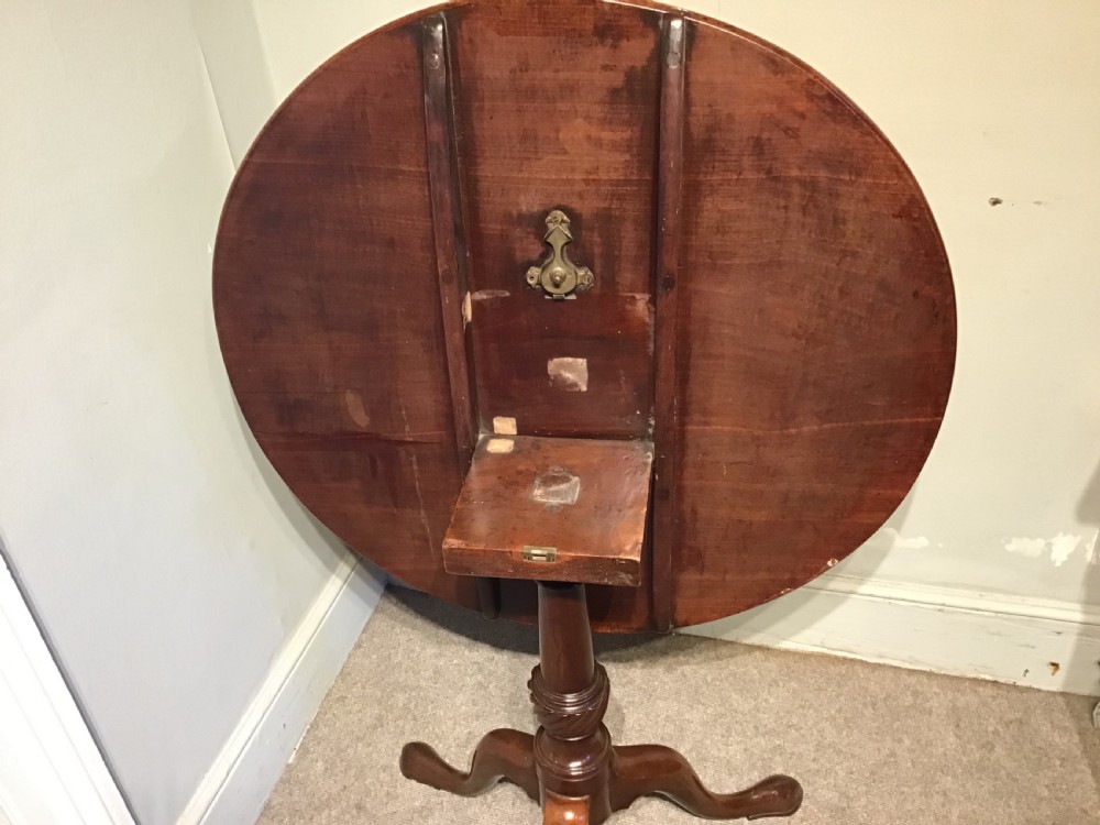 A dark mahogany circular tripod table with a turned central column featuring spiral carving and three cabriole legs with pad feet. View XI