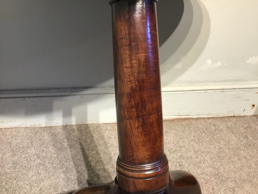 An 18th-century Georgian mahogany tripod table featuring a circular top, a central turned pedestal column, and three splayed cabriole legs. View V