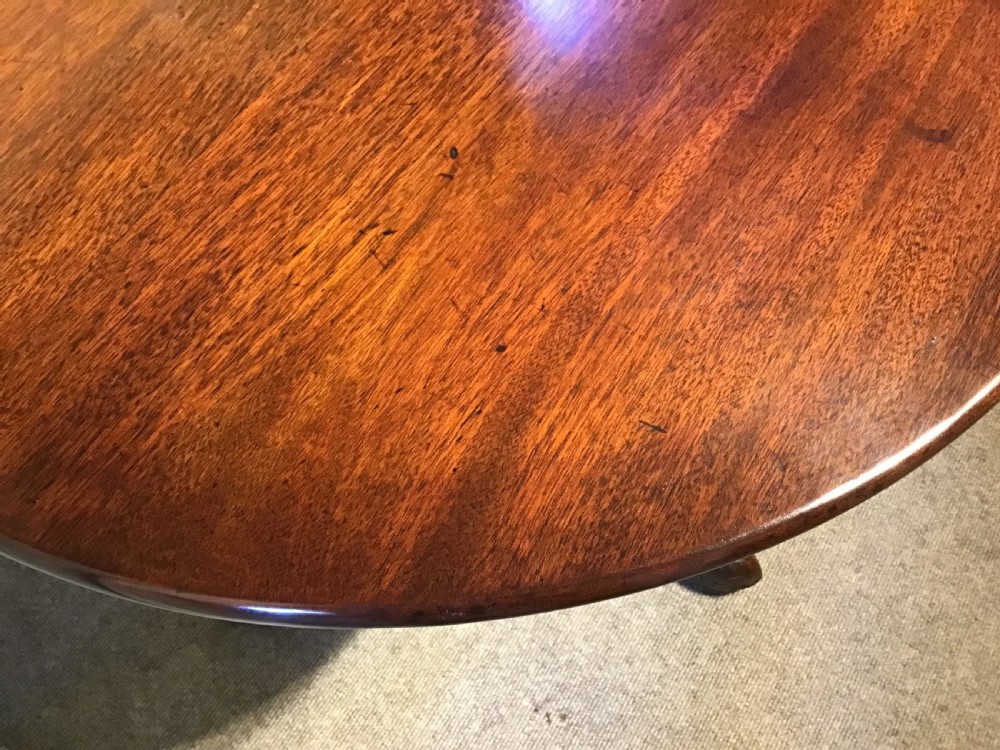 An 18th-century Georgian mahogany tripod table featuring a circular top, a central turned pedestal column, and three splayed cabriole legs. View IX