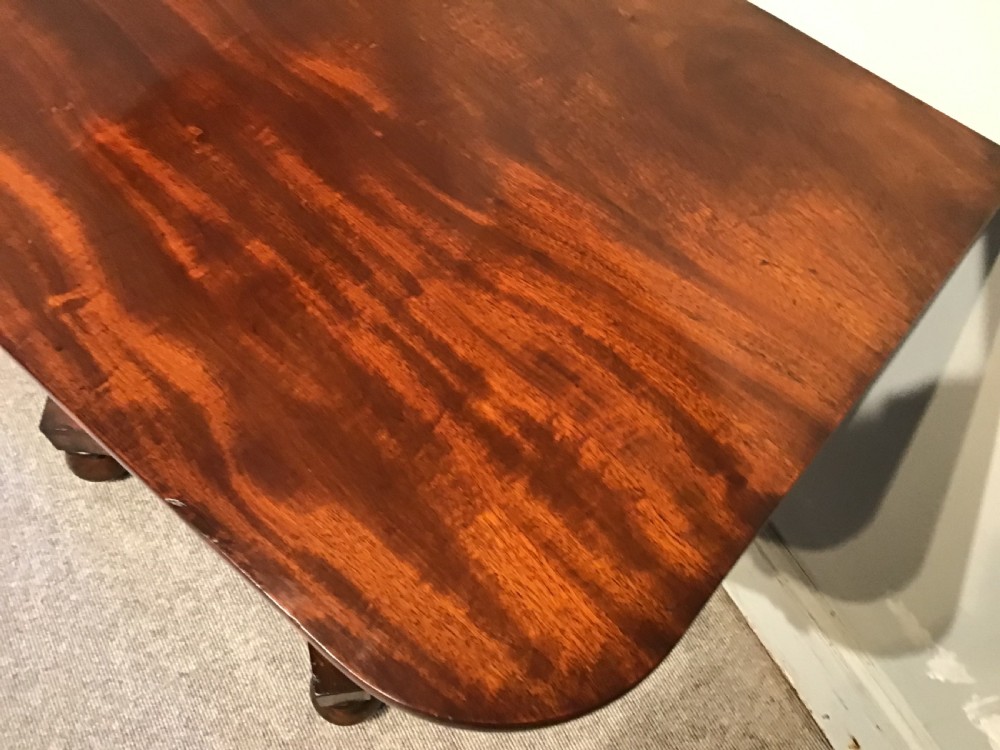 A Regency period flame mahogany fold-over card table featuring a carved pedestal column, a quadruped platform base, and scroll corner brackets. View IV