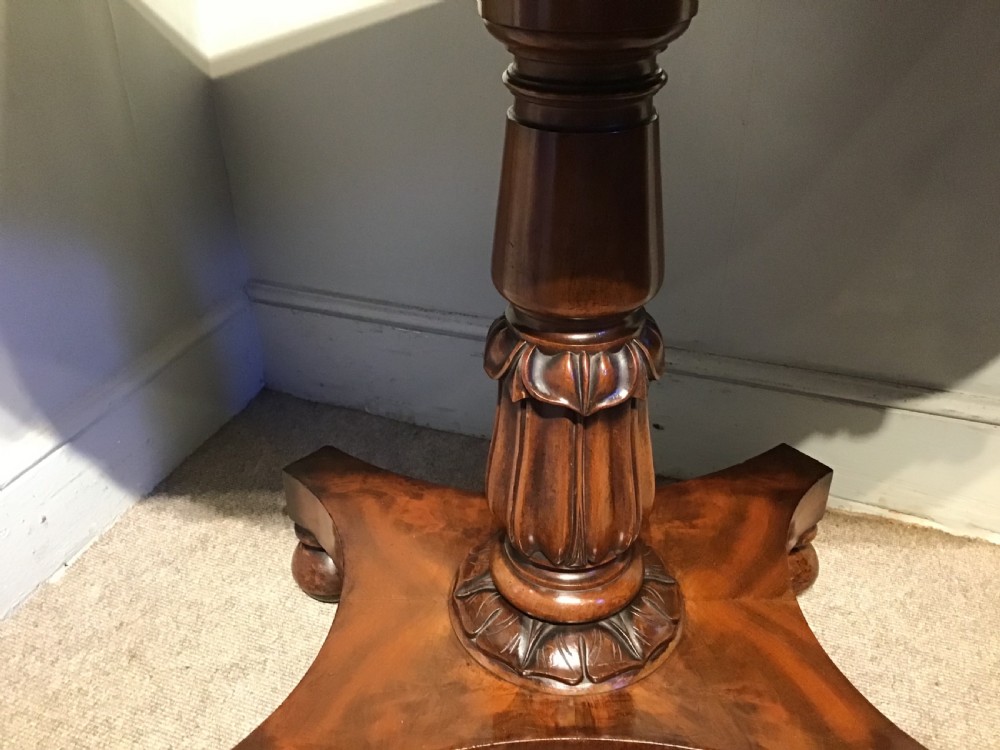 A Regency period flame mahogany fold-over card table featuring a carved pedestal column, a quadruped platform base, and scroll corner brackets. View VIII