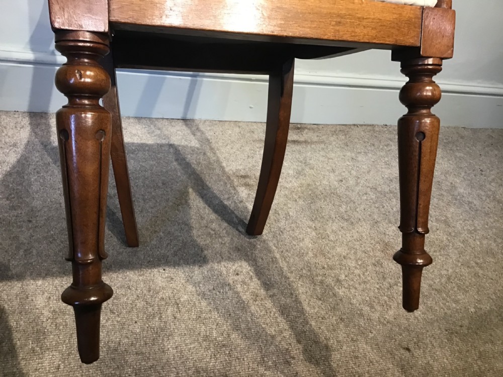 A set of eight Victorian mahogany balloon back dining chairs featuring turned front legs and light cream patterned upholstered seats. View VII