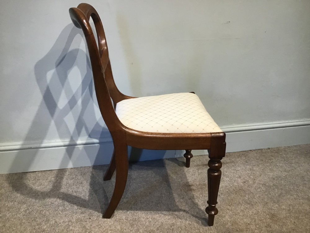 A set of eight Victorian mahogany balloon back dining chairs featuring turned front legs and light cream patterned upholstered seats. View VIII