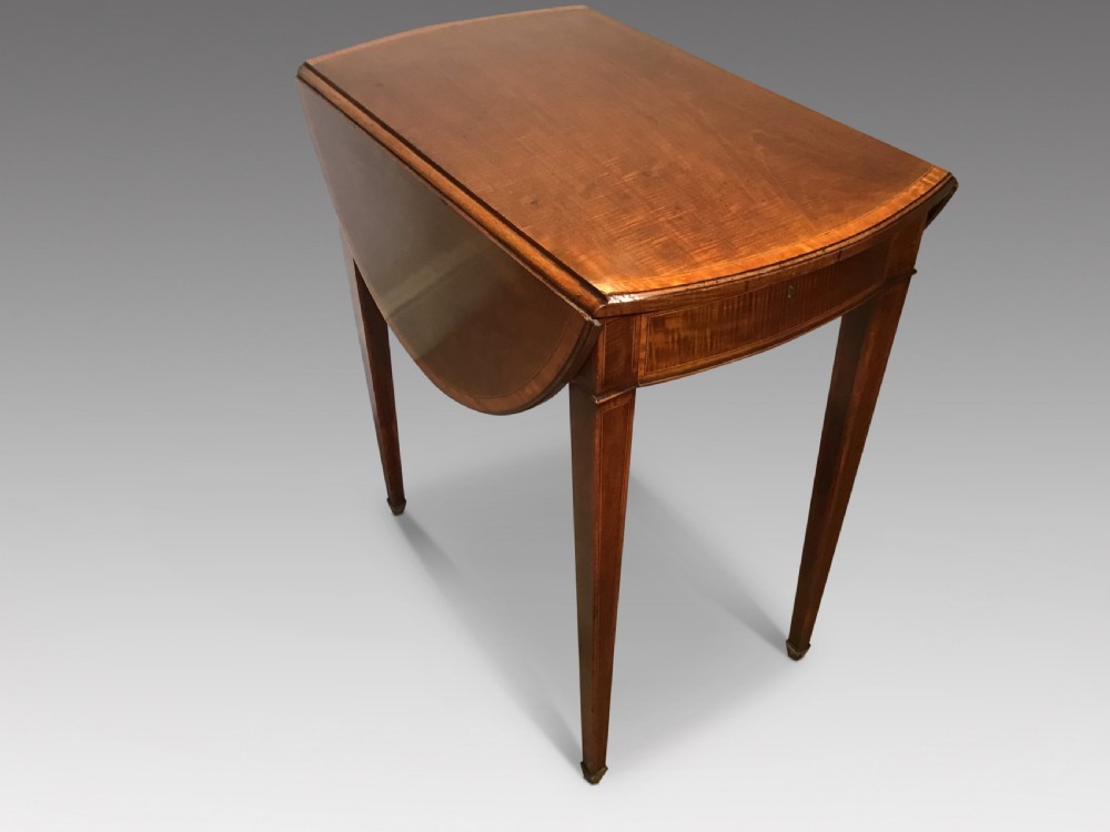 An antique Georgian mahogany Pembroke table with two folded drop leaves, satinwood stringing inlay, and slender square tapered legs.