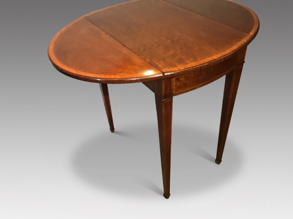 An antique Georgian mahogany Pembroke table with two folded drop leaves, satinwood stringing inlay, and slender square tapered legs. View II