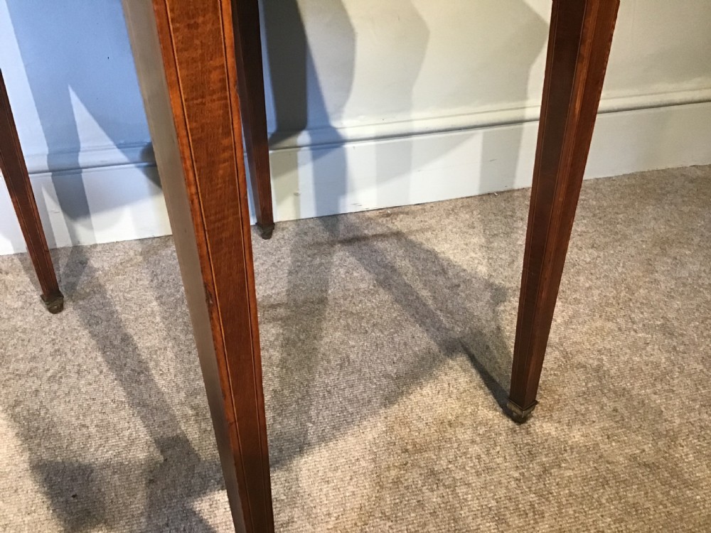 An antique Georgian mahogany Pembroke table with two folded drop leaves, satinwood stringing inlay, and slender square tapered legs. View III