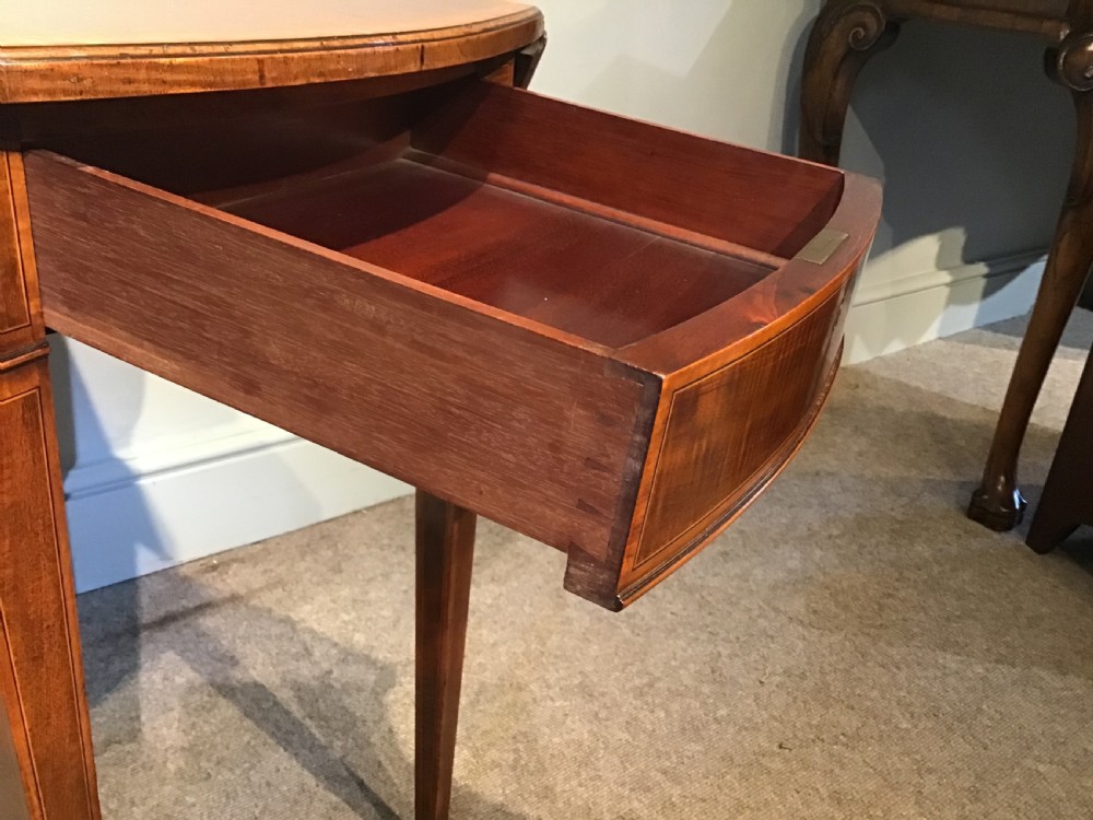 An antique Georgian mahogany Pembroke table with two folded drop leaves, satinwood stringing inlay, and slender square tapered legs. View V