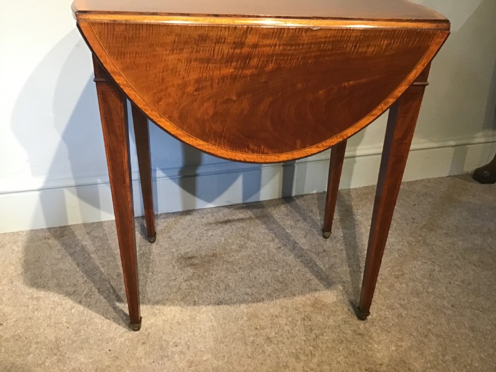 An antique Georgian mahogany Pembroke table with two folded drop leaves, satinwood stringing inlay, and slender square tapered legs. View VII