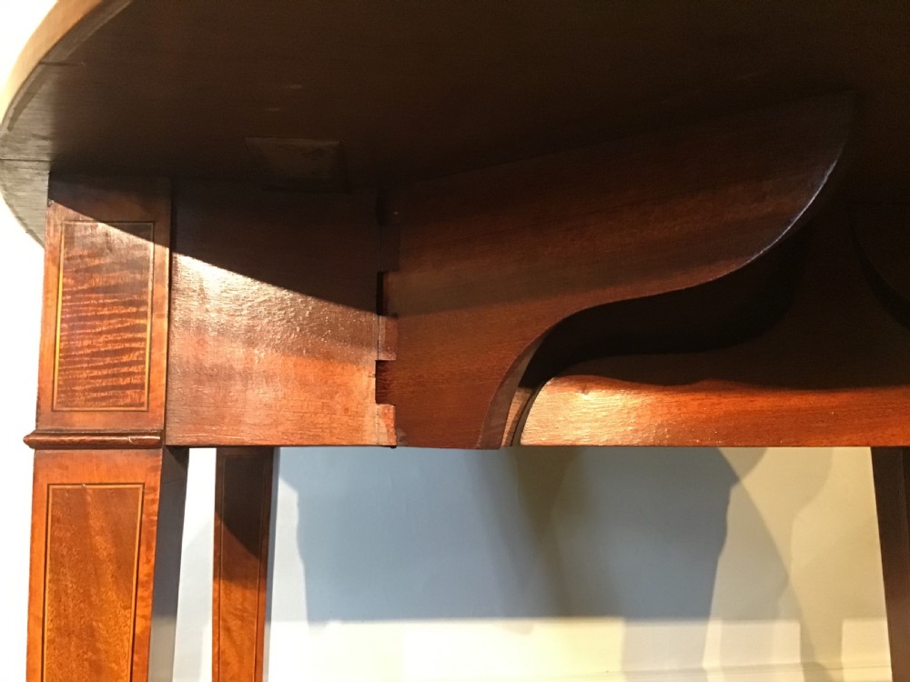 An antique Georgian mahogany Pembroke table with two folded drop leaves, satinwood stringing inlay, and slender square tapered legs. View IX