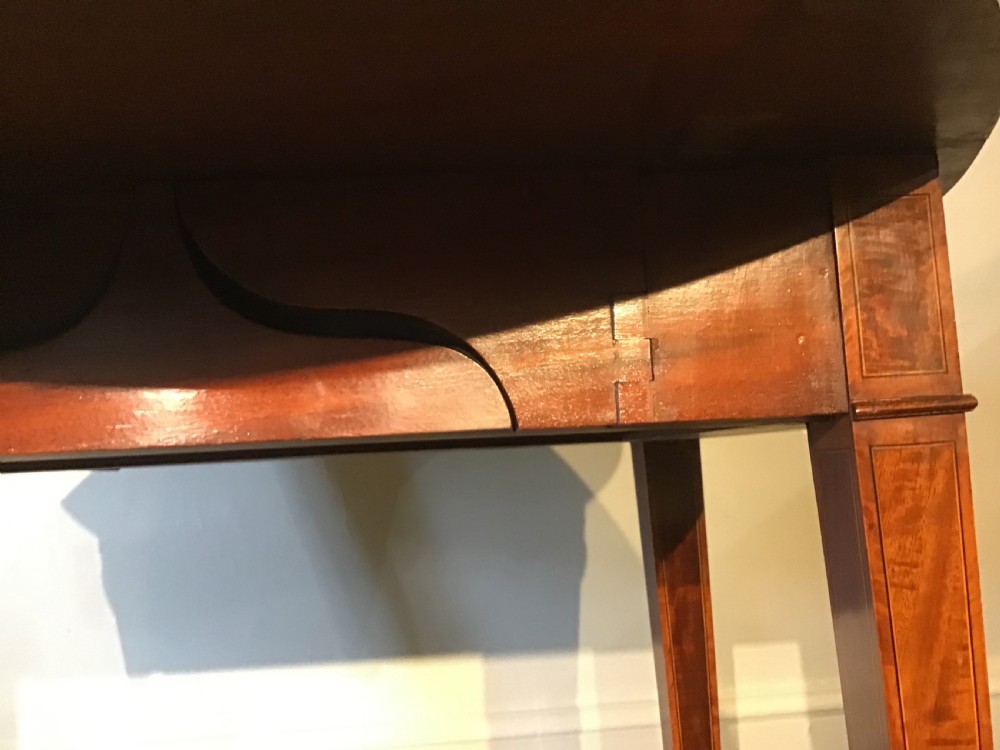 An antique Georgian mahogany Pembroke table with two folded drop leaves, satinwood stringing inlay, and slender square tapered legs. View X