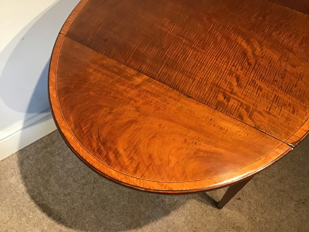 An antique Georgian mahogany Pembroke table with two folded drop leaves, satinwood stringing inlay, and slender square tapered legs. View XIII