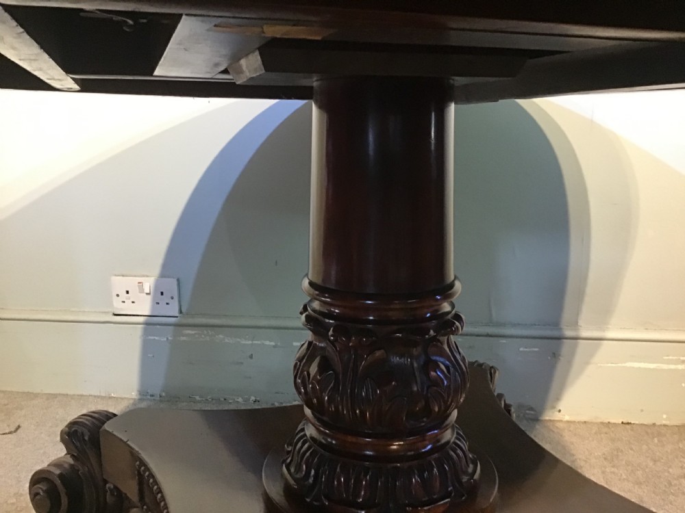 A circular antique Goncalo Alves centre table featuring a figured timber top and a pedestal base with carved scroll feet. View V