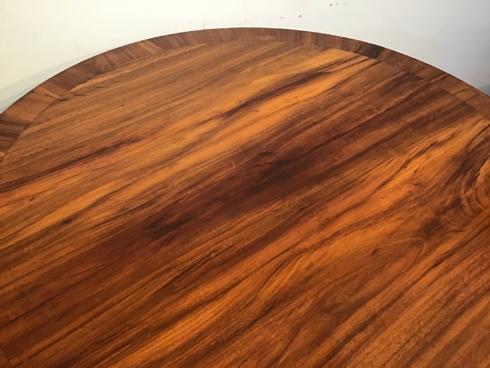 A circular antique Goncalo Alves centre table featuring a figured timber top and a pedestal base with carved scroll feet. View VIII
