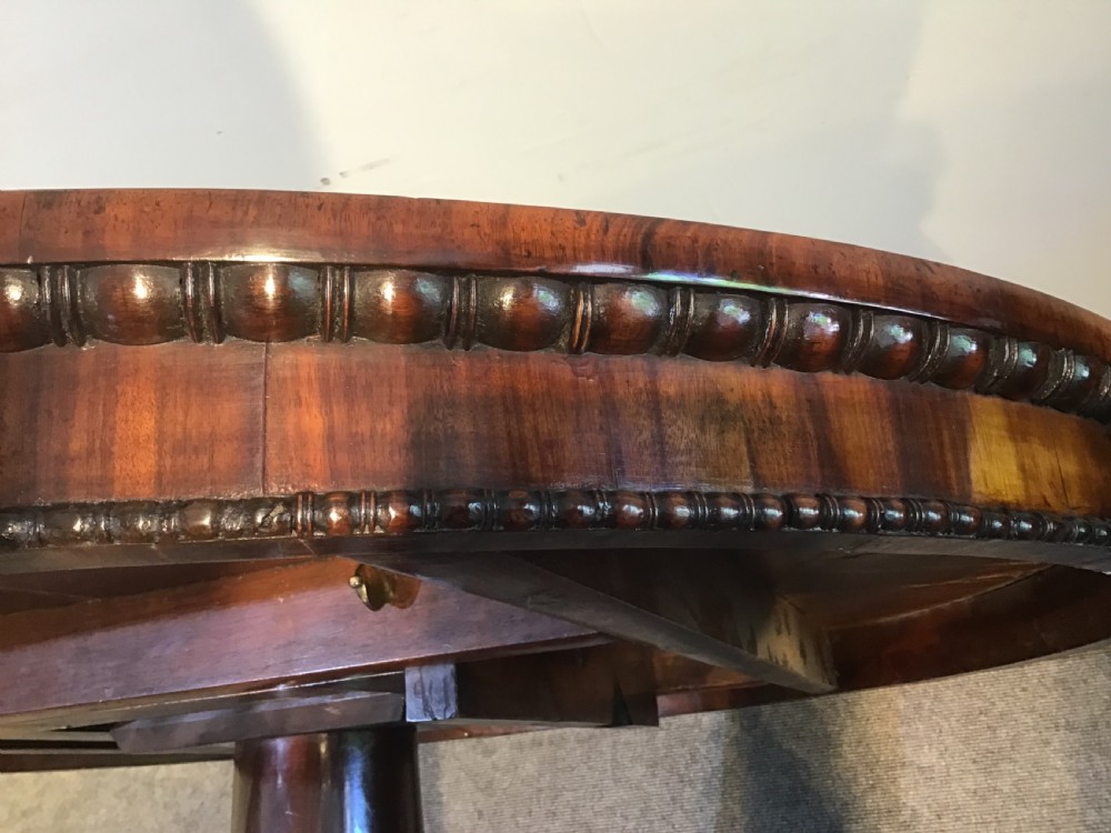 A circular antique Goncalo Alves centre table featuring a figured timber top and a pedestal base with carved scroll feet. View XIV