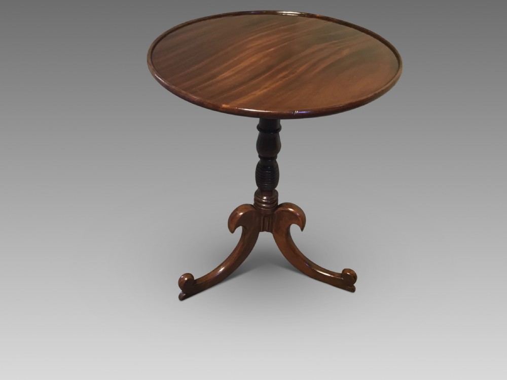 An antique mahogany low tripod table