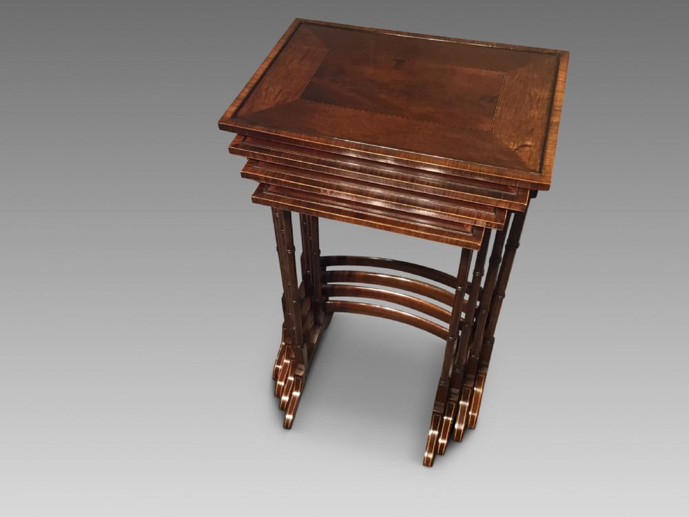 A set of four graduated dark mahogany nested tables featuring turned legs, curved rear stretchers, and splayed feet. View II