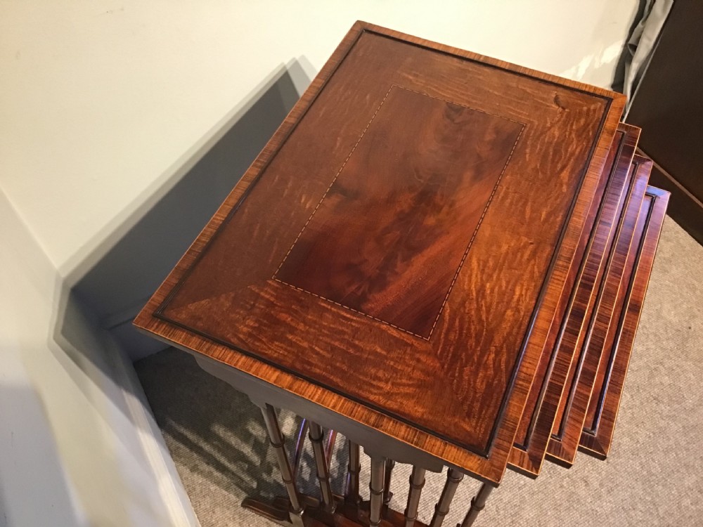 A set of four graduated dark mahogany nested tables featuring turned legs, curved rear stretchers, and splayed feet. View IV