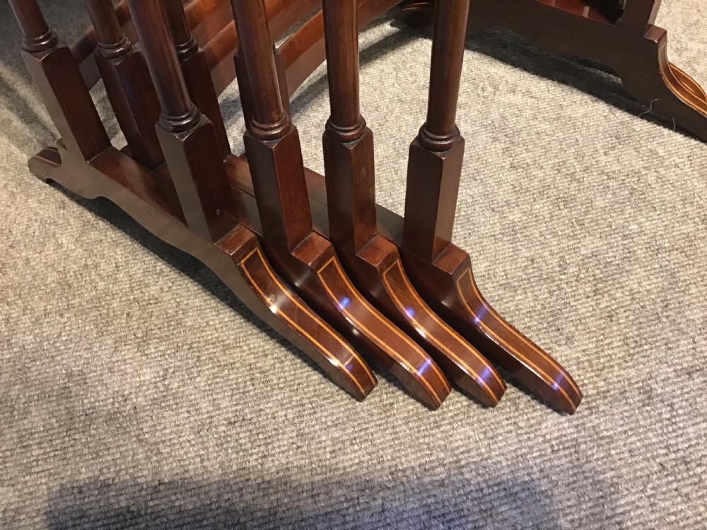 A set of four graduated dark mahogany nested tables featuring turned legs, curved rear stretchers, and splayed feet. View VI