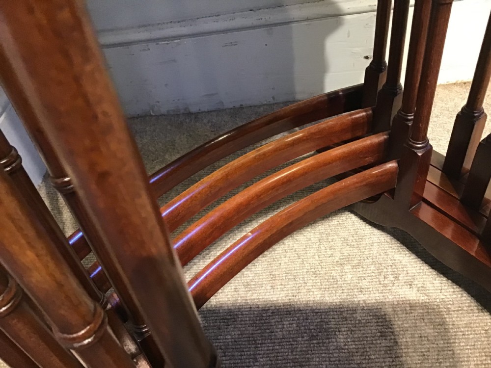 A set of four graduated dark mahogany nested tables featuring turned legs, curved rear stretchers, and splayed feet. View VII