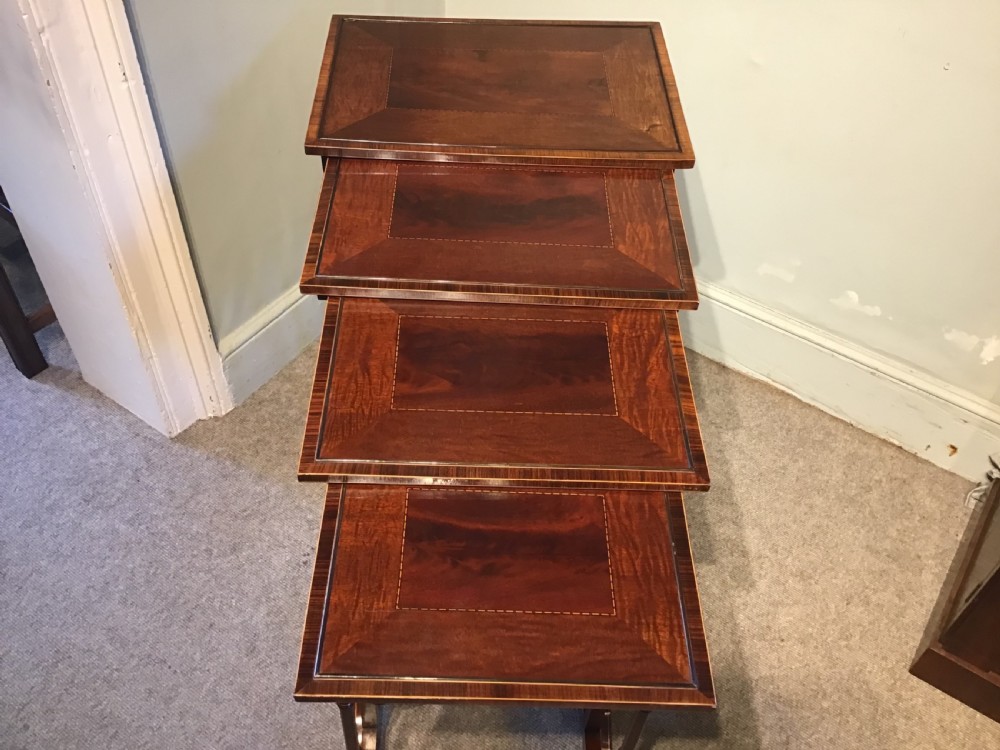 A set of four graduated dark mahogany nested tables featuring turned legs, curved rear stretchers, and splayed feet. View VIII