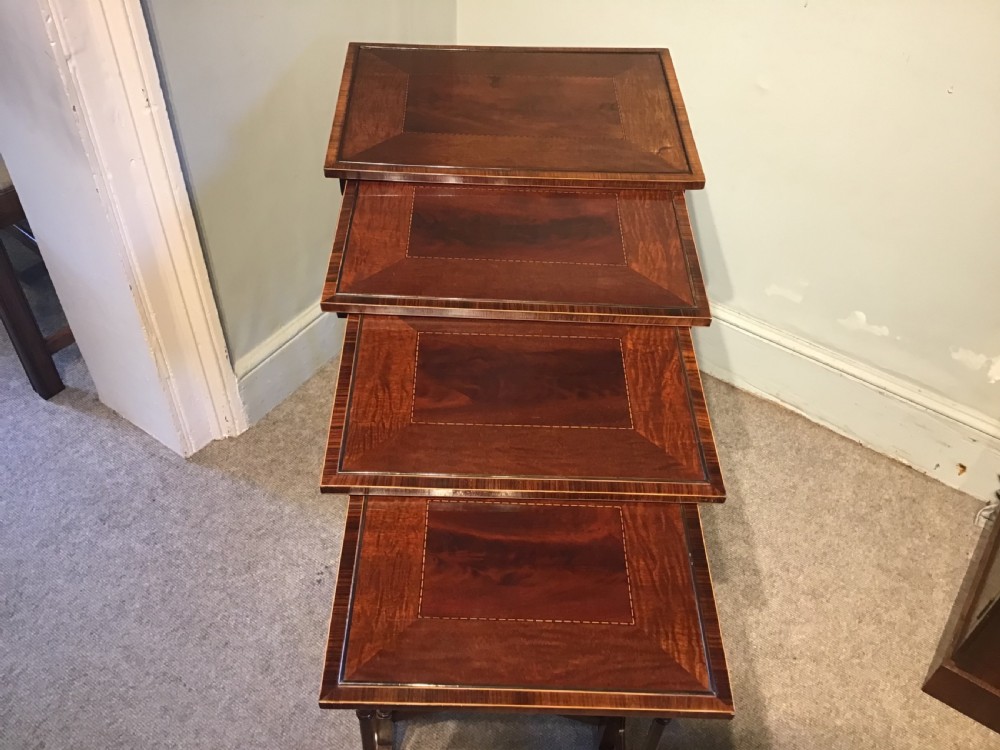 A set of four graduated dark mahogany nested tables featuring turned legs, curved rear stretchers, and splayed feet. View IX