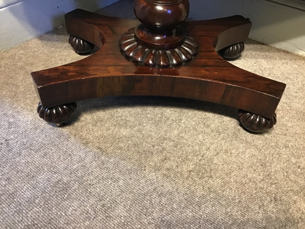 An antique rosewood fold-over card table with a beaded frieze, central turned pedestal stem, and a quadripartite plinth base on carved feet. View III