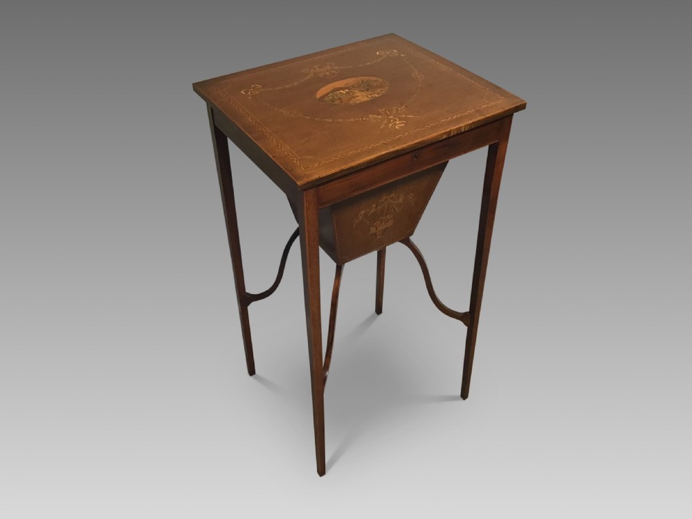An antique inlaid mahogany work table