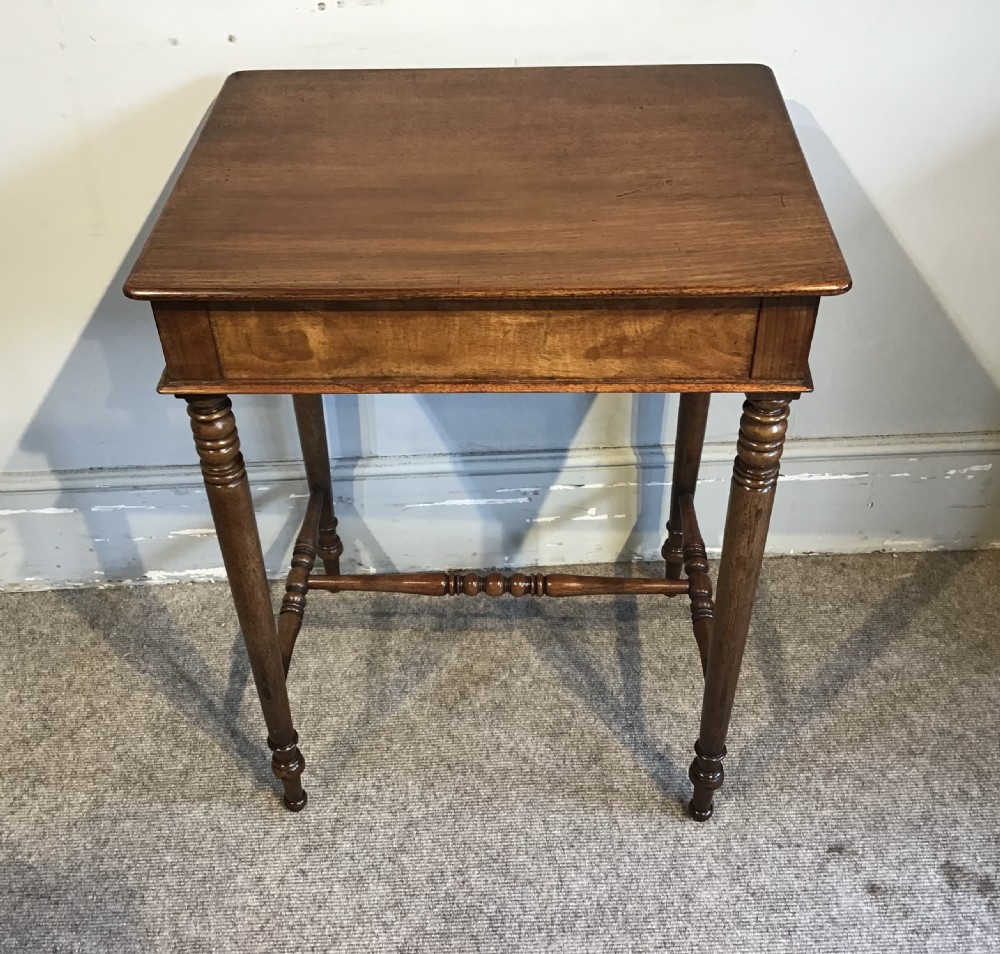 A Regency mahogany side table with a rectangular top, single drawer with brass pull, turned legs, and lower stretchers. View V