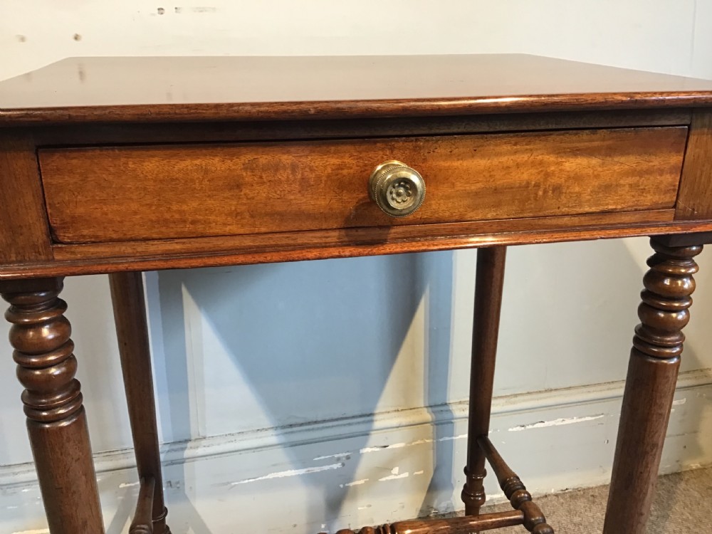 A Regency mahogany side table with a rectangular top, single drawer with brass pull, turned legs, and lower stretchers. View VI