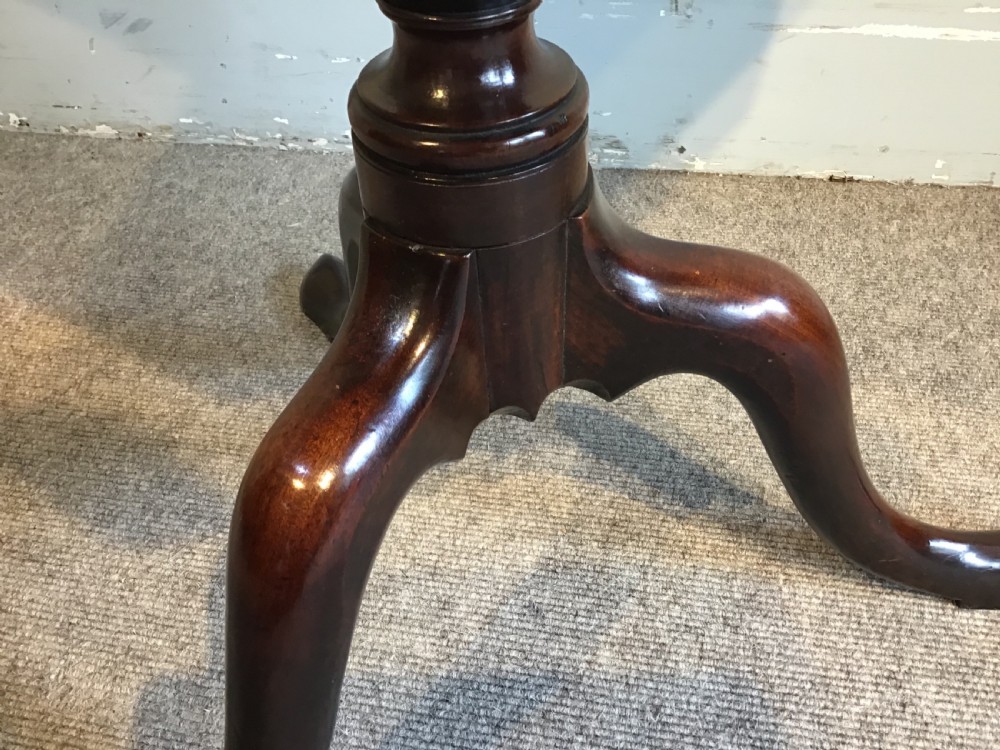 A dark mahogany Georgian tripod table with a canted rectangular top, central turned column, and three cabriole legs. View V