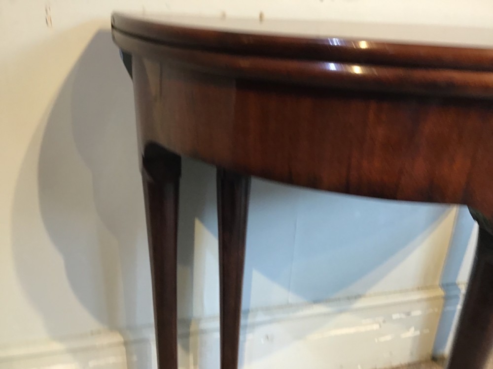A Georgian mahogany semi-circular fold-over tea table featuring slender legs terminating in pad feet and a brass keyhole escutcheon. View VII