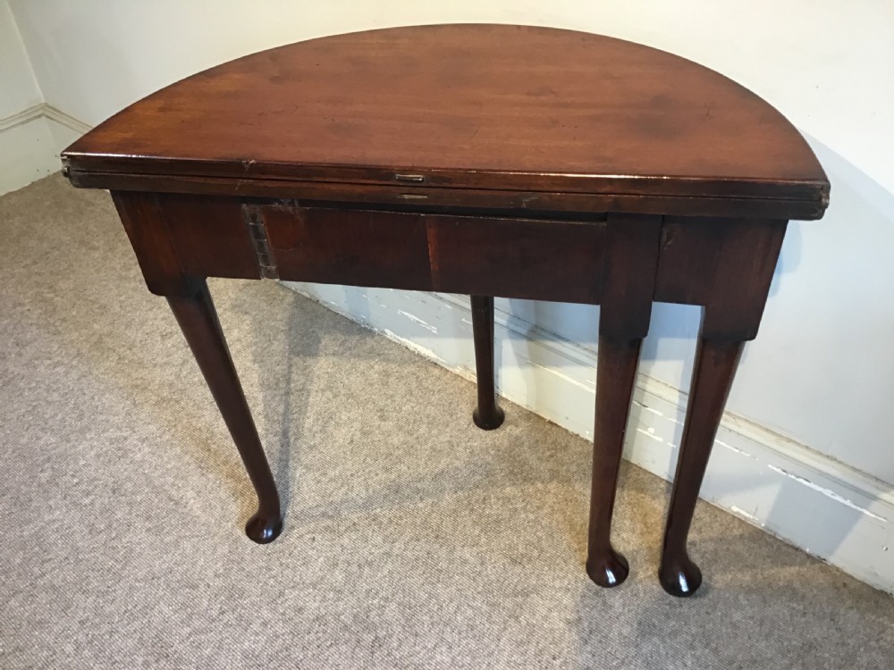 A Georgian mahogany semi-circular fold-over tea table featuring slender legs terminating in pad feet and a brass keyhole escutcheon. View XI
