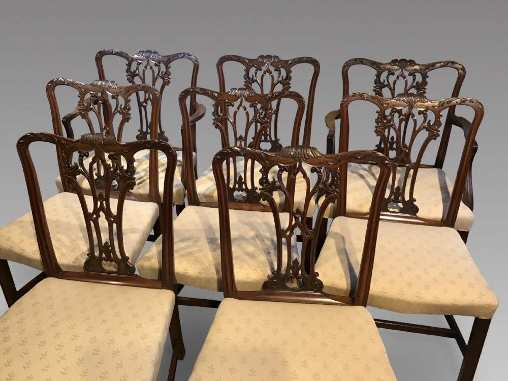 A set of eight Georgian mahogany dining chairs featuring intricate carved pierced back splats and cream patterned upholstered seats. View III