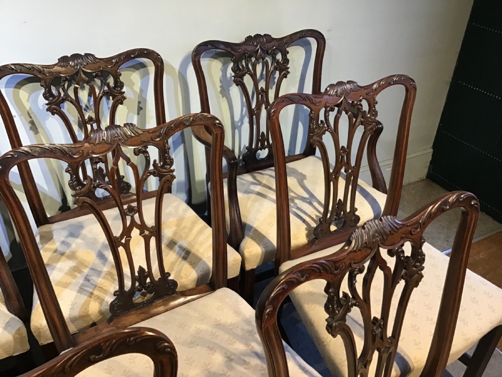 A set of eight Georgian mahogany dining chairs featuring intricate carved pierced back splats and cream patterned upholstered seats. View XIV