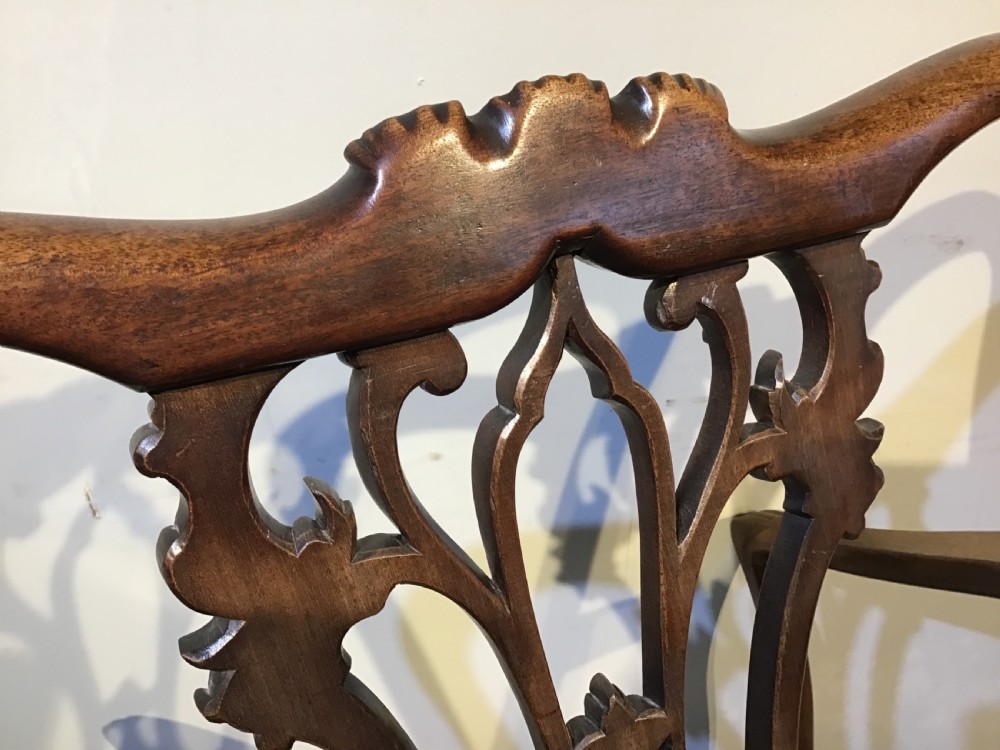 A set of eight Georgian mahogany dining chairs featuring intricate carved pierced back splats and cream patterned upholstered seats. View XV