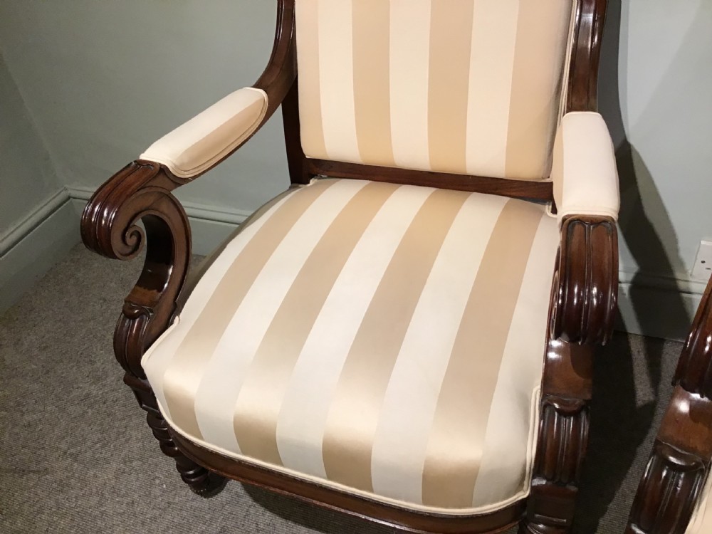 A pair of antique mahogany armchairs featuring tall arched backs, cream striped upholstery, scrolled armrests, and turned legs on castors. View III