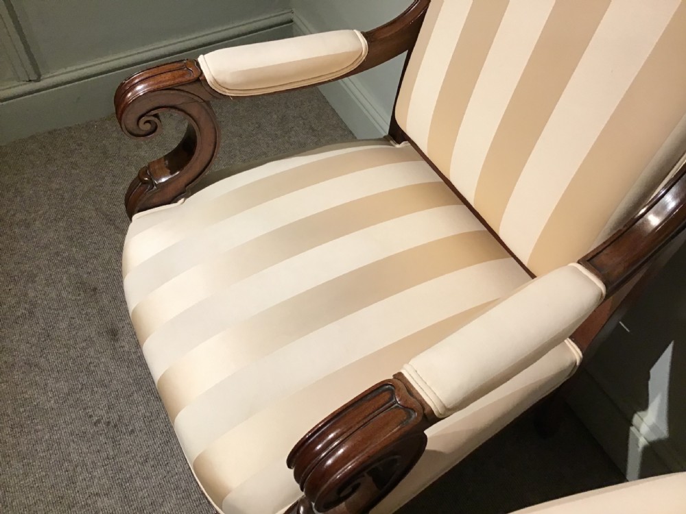 A pair of antique mahogany armchairs featuring tall arched backs, cream striped upholstery, scrolled armrests, and turned legs on castors. View VII