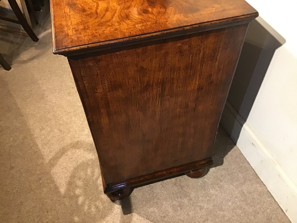 An antique burr walnut chest of drawers with two short over three long drawers, brass handles, and bun feet. View XI
