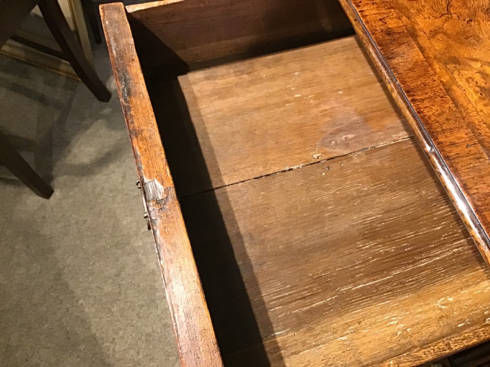 An antique burr walnut chest of drawers with two short over three long drawers, brass handles, and bun feet. View XIII
