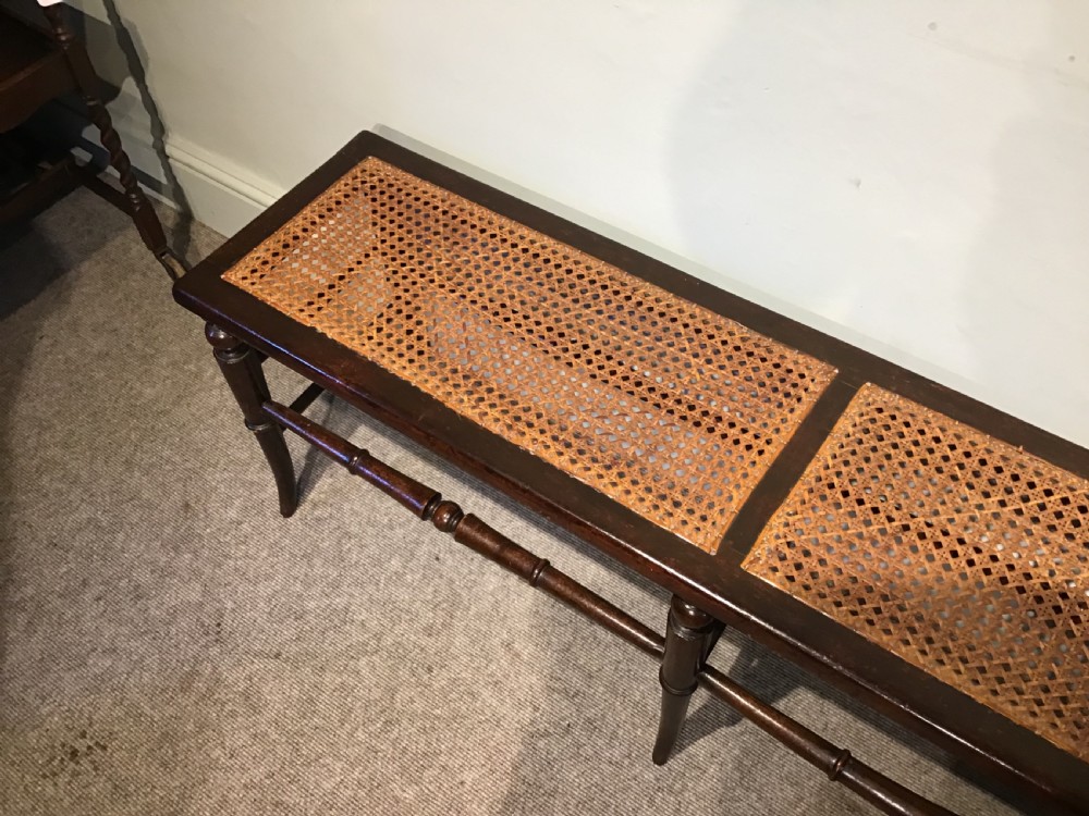 An antique beech and cane long stool View II