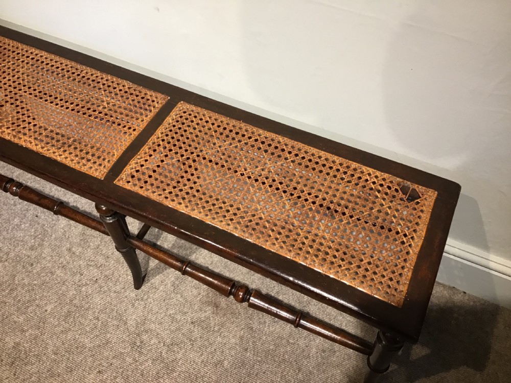 An antique beech and cane long stool View III