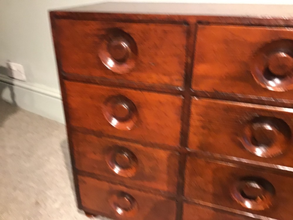 A pair of antique brown wooden apothecary chests, each featuring eight drawers with carved circular recessed handles. View V