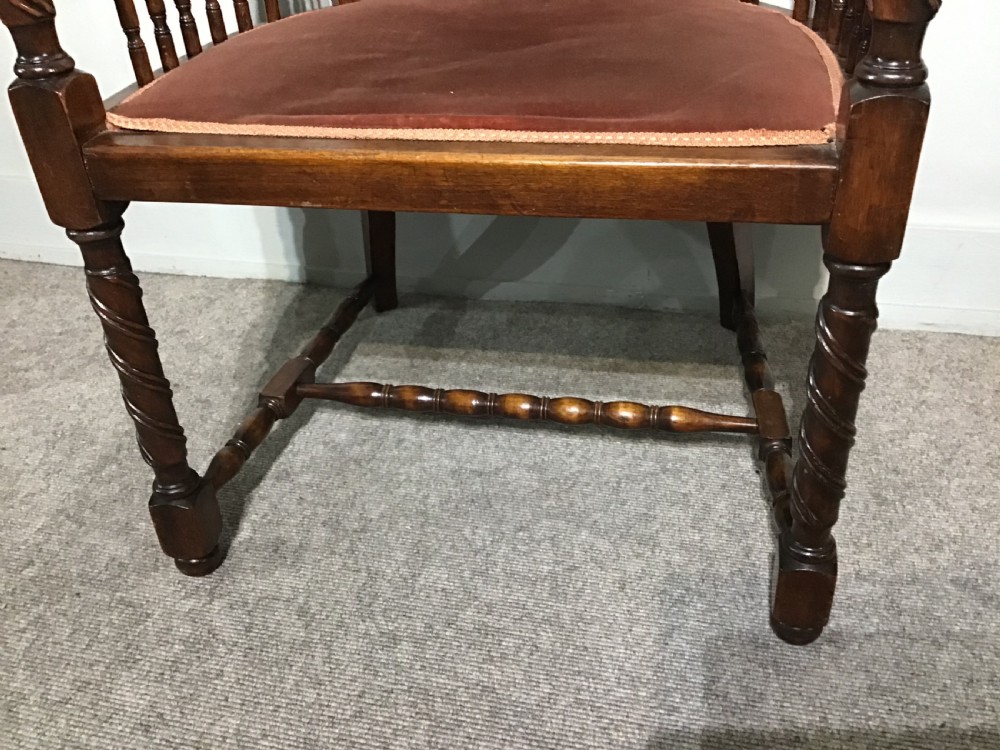 An antique mahogany tub chair featuring a woven cane back panel, turned side spindles, barley twist legs, and a dark brown upholstered seat. View VI